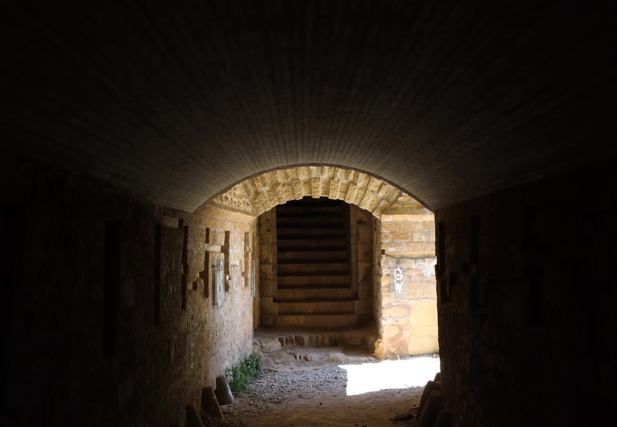 A tunnel in a fort, light shines in the other end