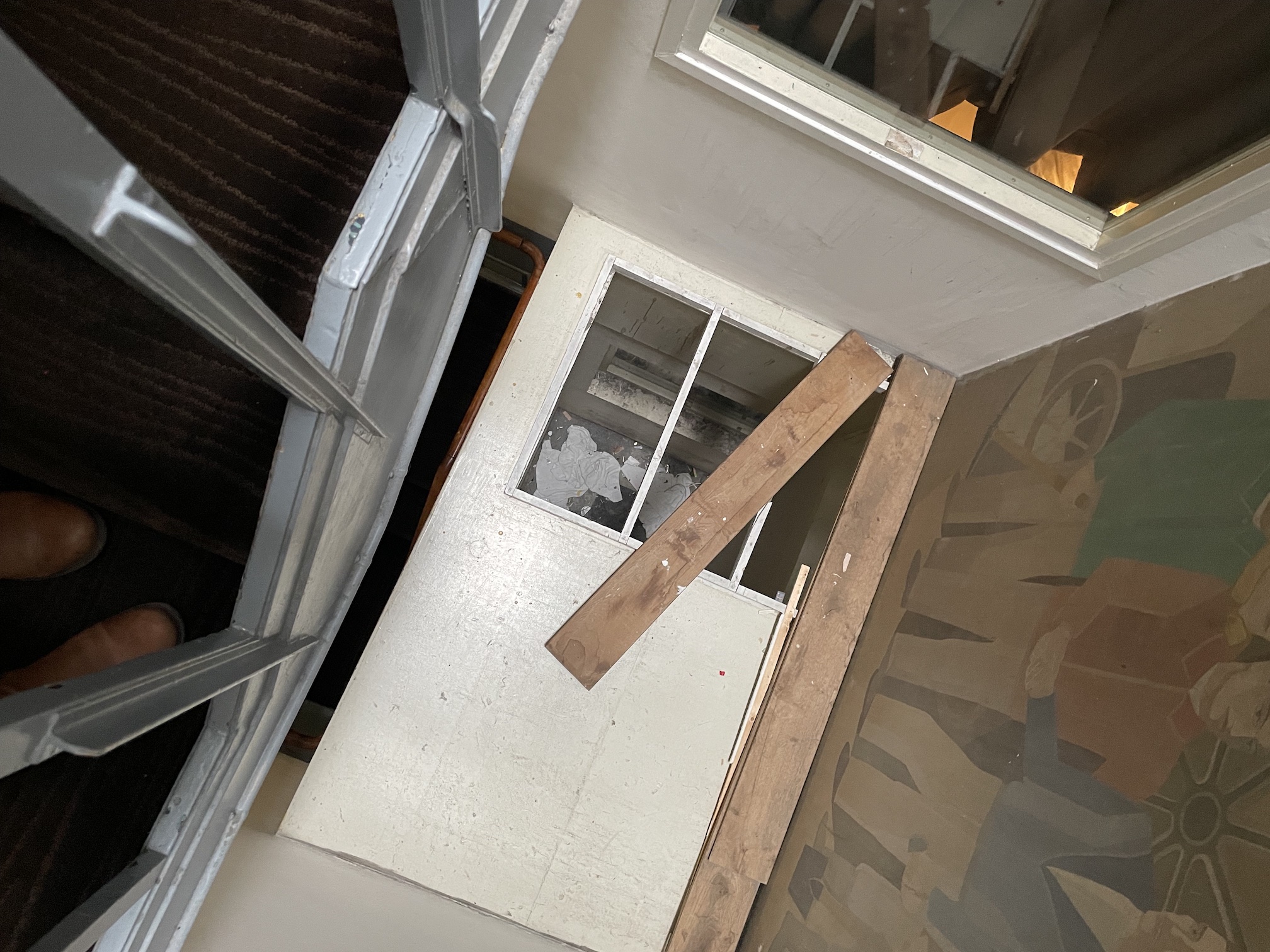 A view looking down a stairwell at some loose boards and sketchy woodwork in an Amsterdam hotel