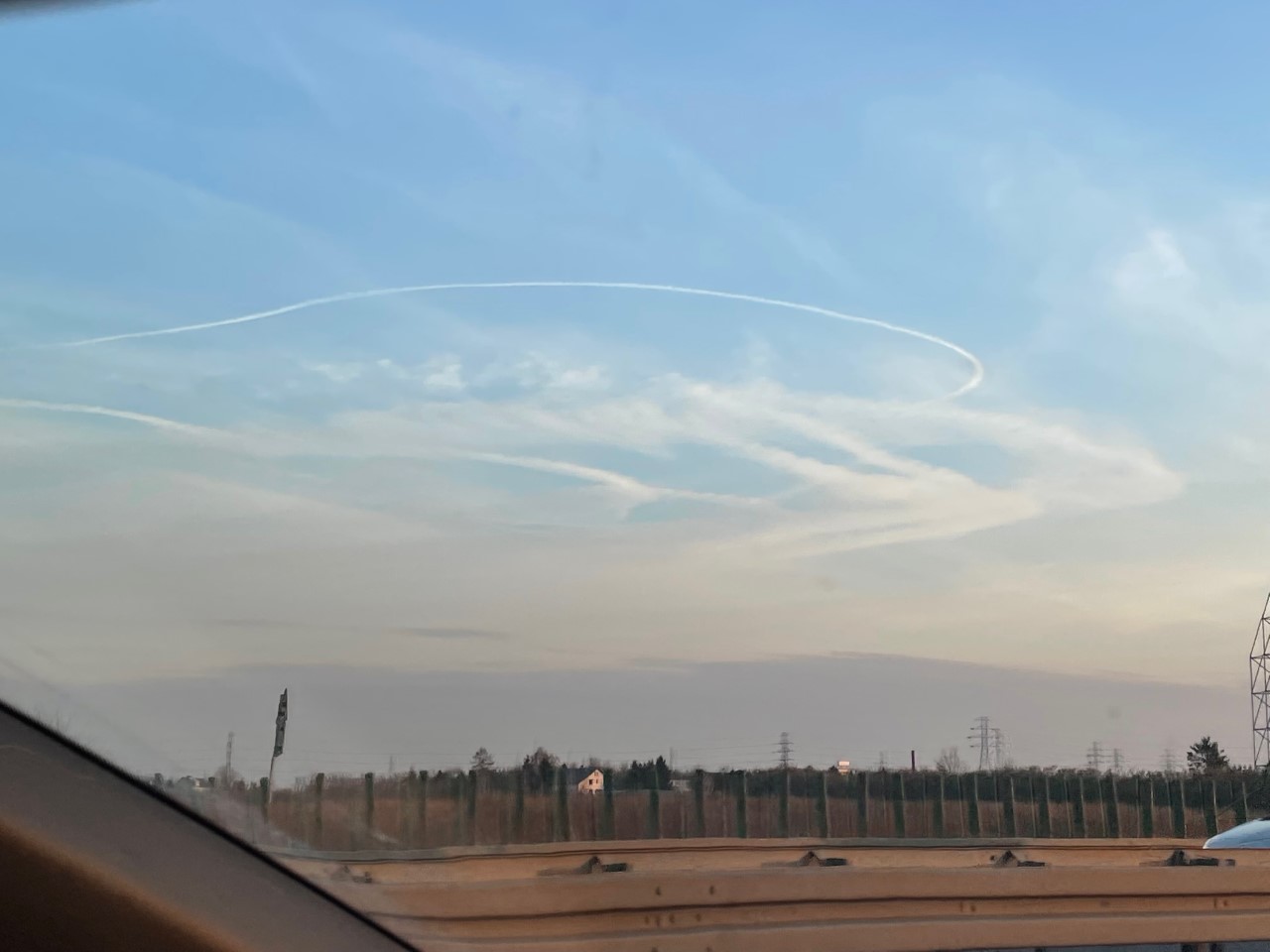 Racetrack pattern contrails against a blue sky